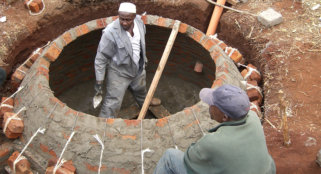 Zwei Männer arbeiten an Biogasanlagen zur Energieversorgung von Haushalten in Kenia